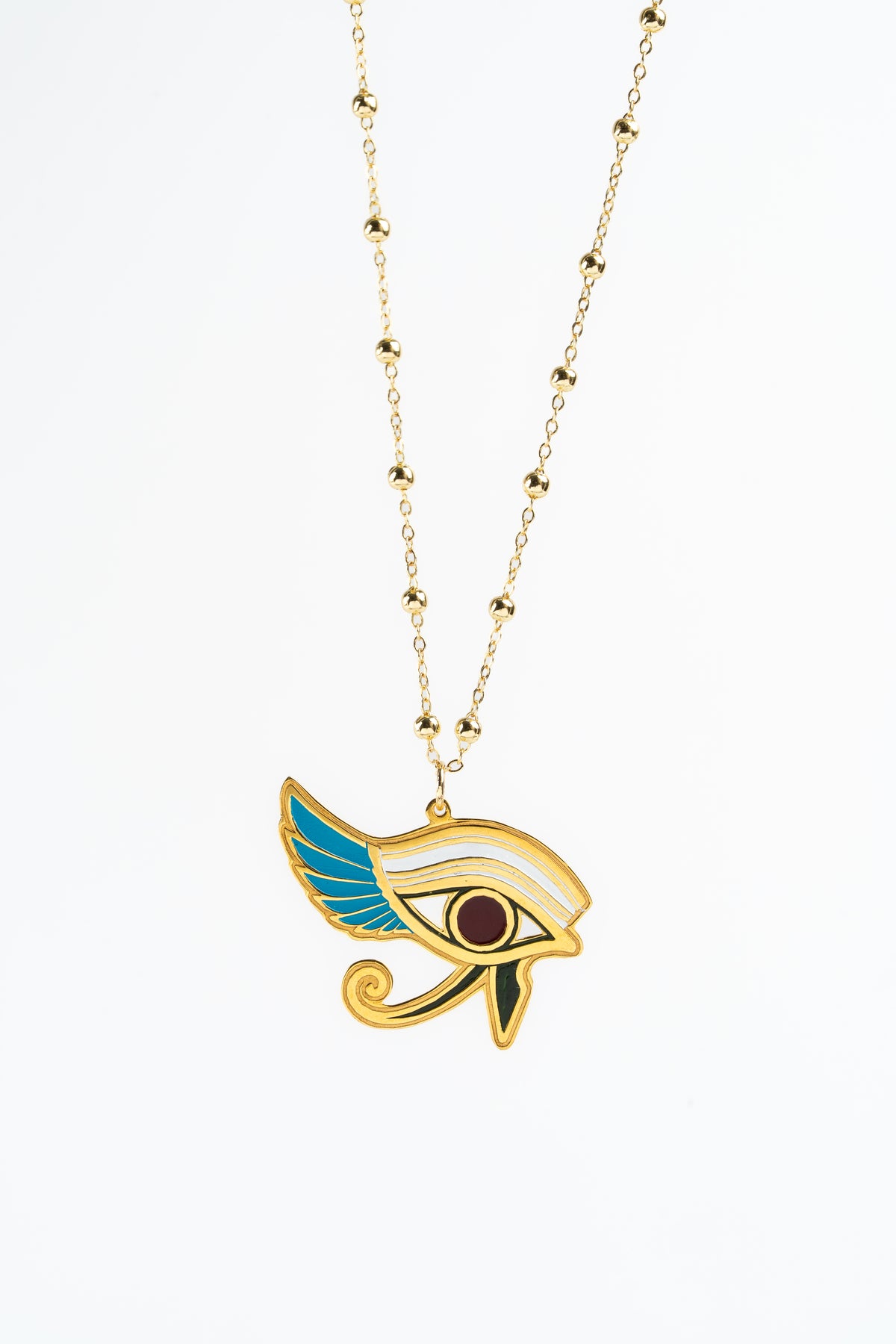 Gold-plated Egyptian Eye of Horus pendant necklace with turquoise , white, and red enamel details on a delicate beaded chain, shown against a plain white background.