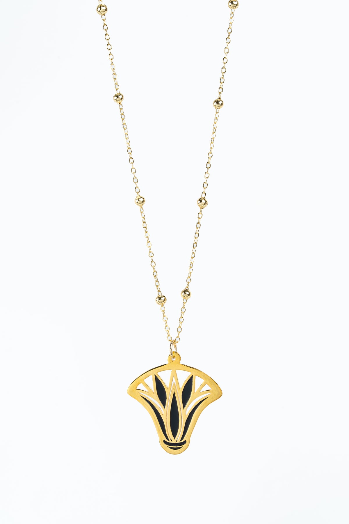 A chain necklace featuring a gold plated ancient egyptian lotus inspired pendant with black inlay details, displayed against a solid white background